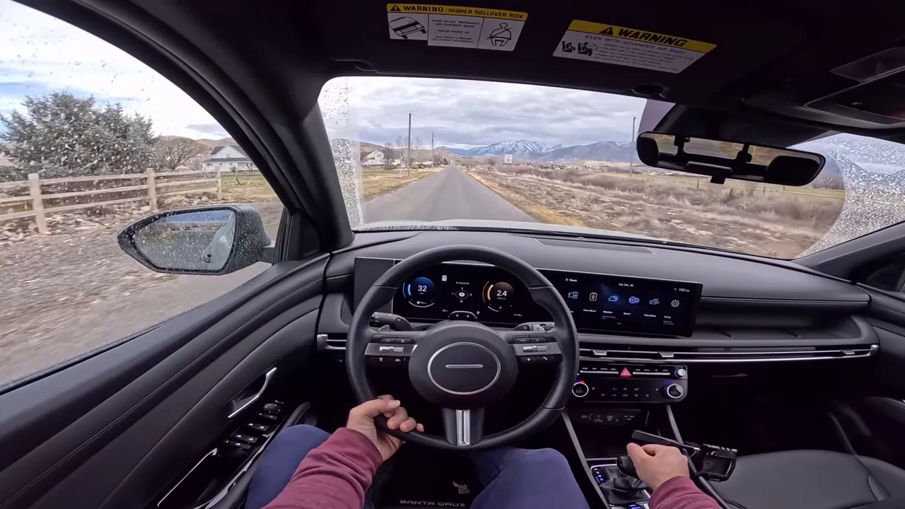 Driver view of Hyundai Santa Cruz interior and road ahead showing steering wheel, instrument cluster and center screen