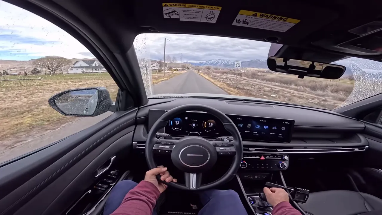Driver perspective interior view of Hyundai Santa Cruz showing steering wheel, center screen and road ahead