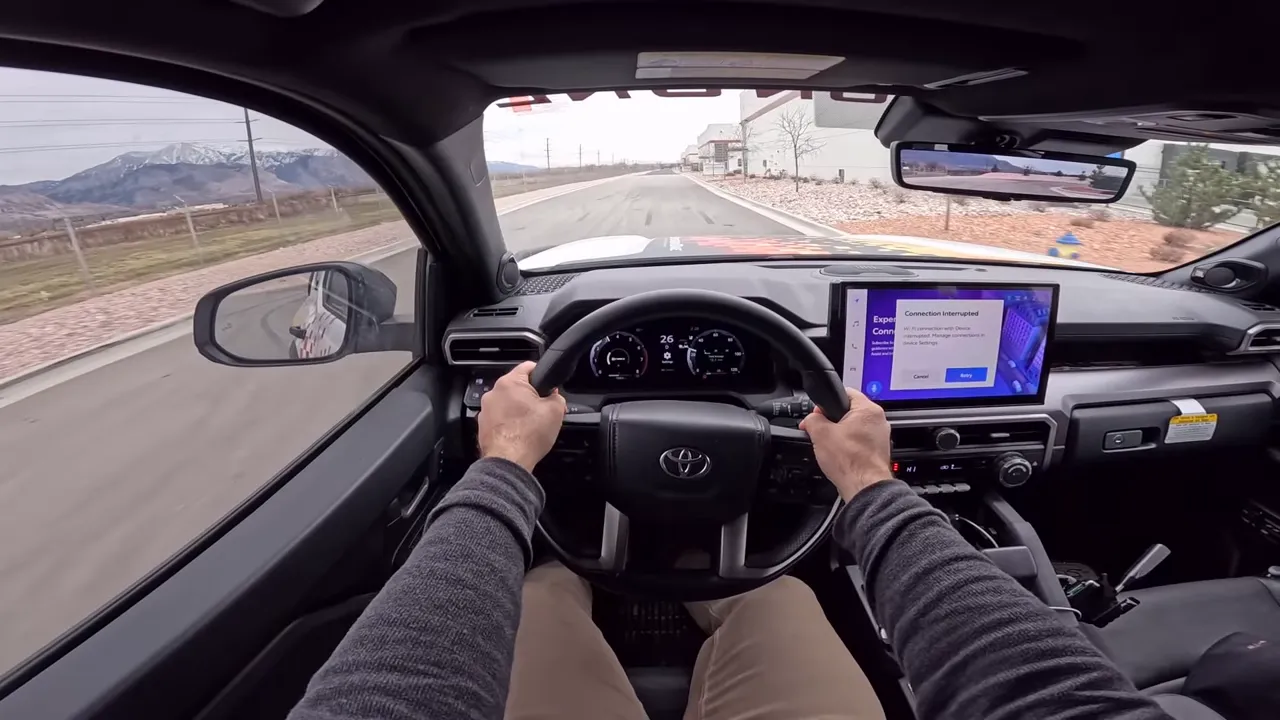 Driver point-of-view inside 4Runner with both hands on steering wheel, instrument cluster and road ahead