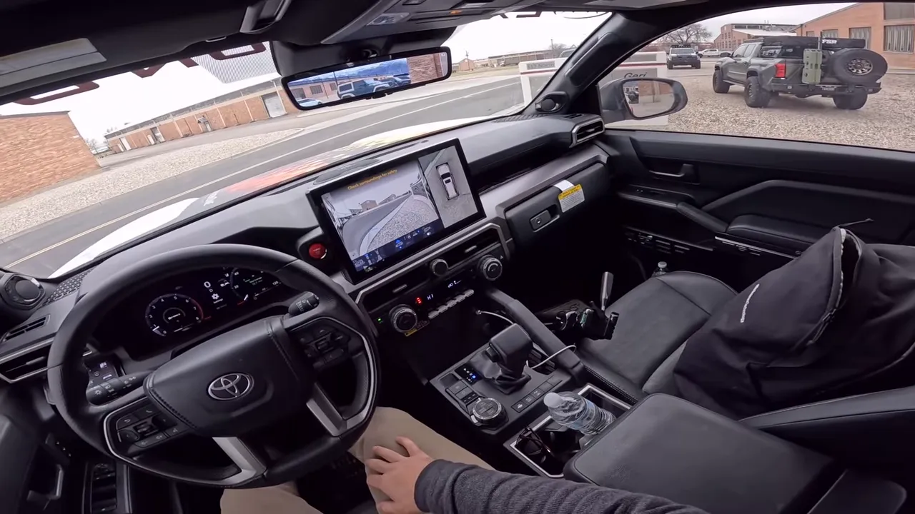 Toyota 4Runner interior showing center touchscreen camera view and rearview mirror displaying rear camera feed, demonstrating retained sensors and cameras