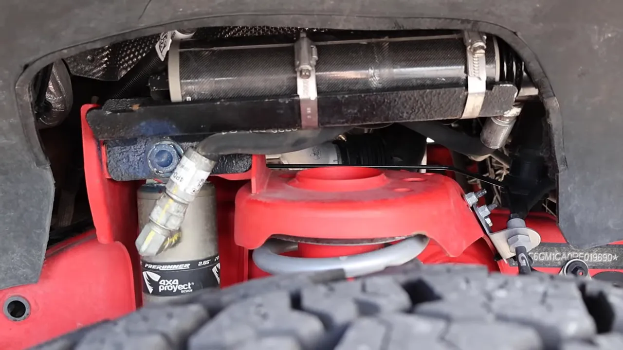 Clear image of a Grenadier rear suspension showing Evictus remote-reservoir shock, hoses, mounting hardware and coil spring