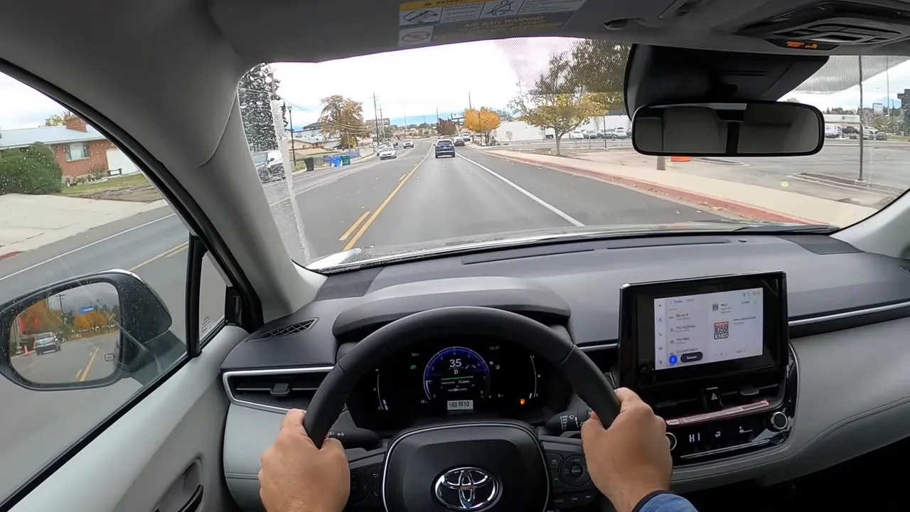 Driver view in 2026 Toyota Corolla Cross showing hands on wheel, instrument cluster and clear road ahead