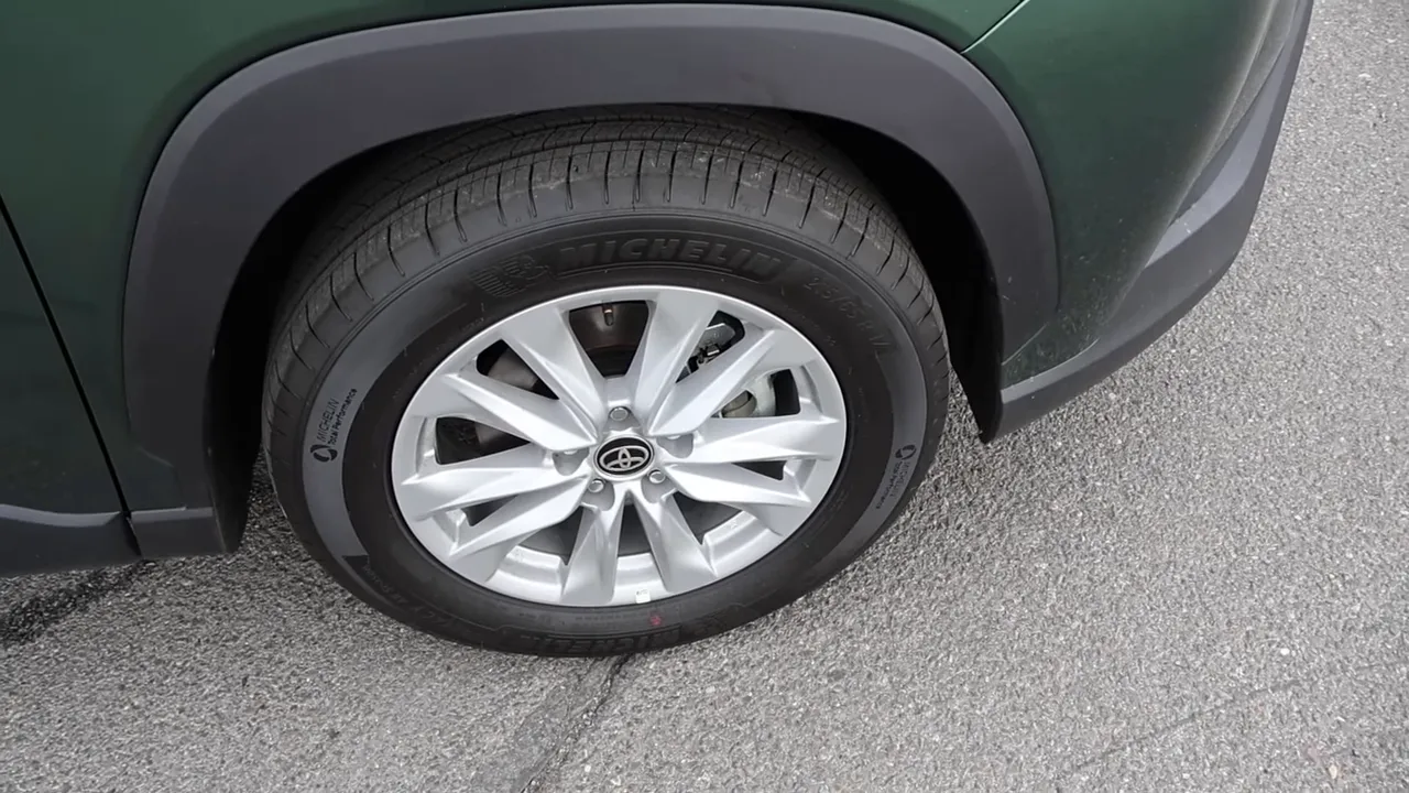 Close-up of 17-inch alloy wheel and 215/65R17 tire on Toyota Corolla Cross with plastic fender flare