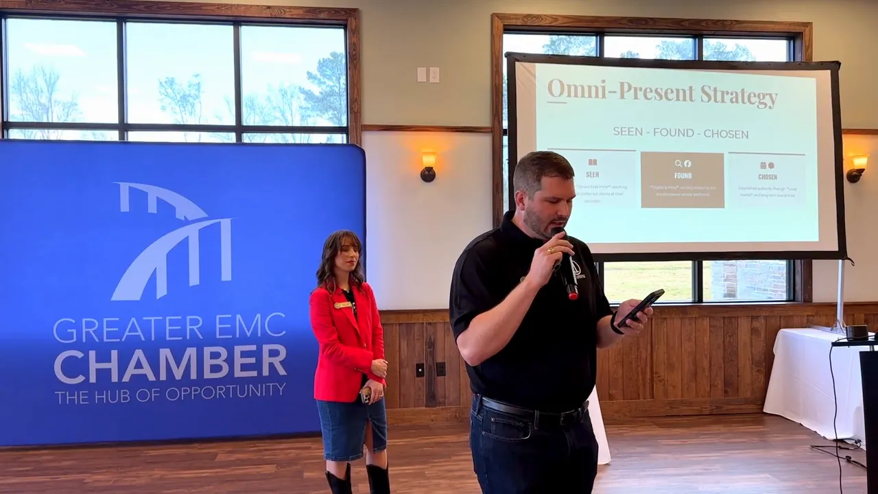 Presenters at a networking breakfast with a Greater EMC Chamber backdrop and a projection slide reading 'Omni-Present Strategy — Seen • Found • Chosen'.