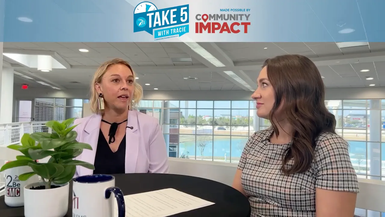 Two-person interview about custom-branded apparel and promotional items, table with paperwork and mugs in foreground.