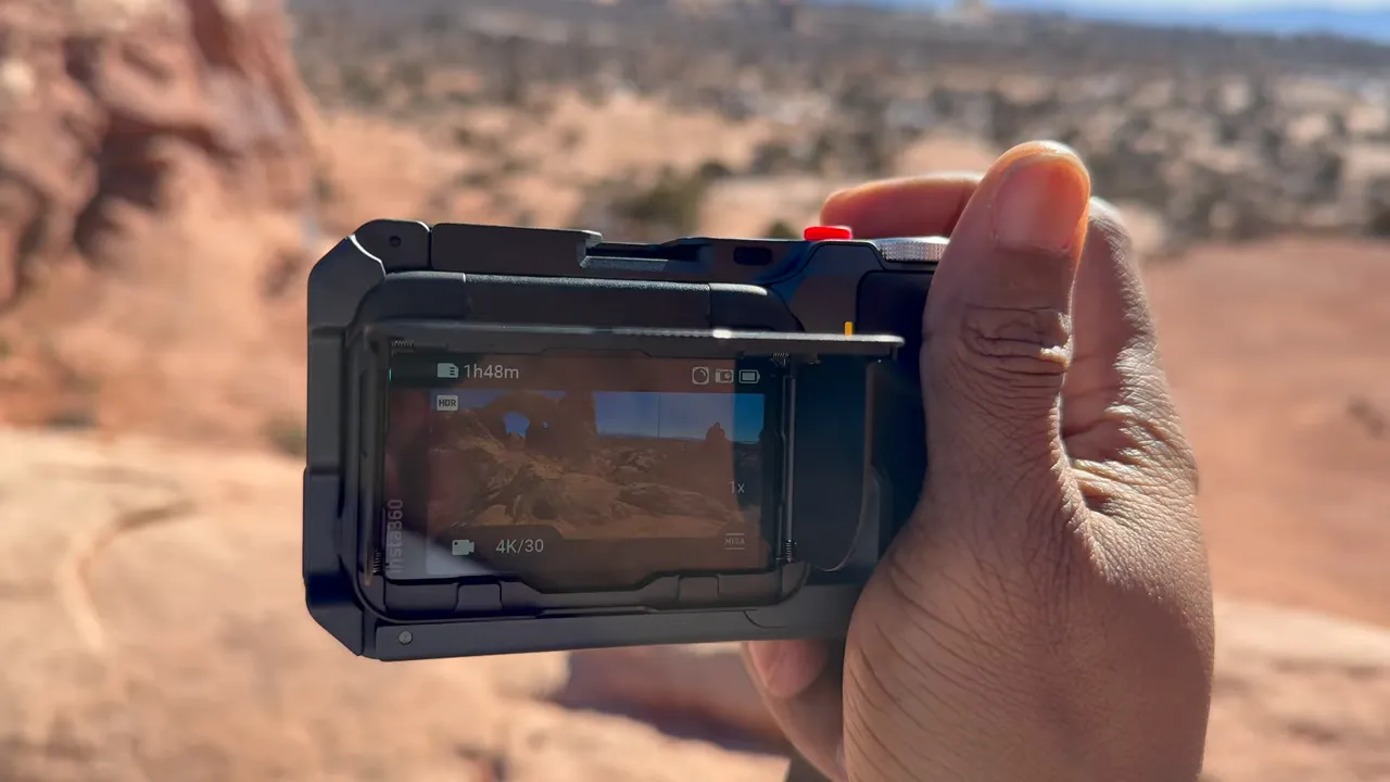 insta360 Ace Pro 2 in the Xplorer Grip Pro with the rear screen visible outdoors in bright light