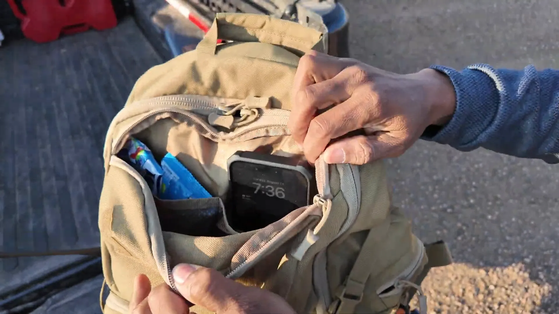 Top pocket open with phone, snacks, and first aid kit
