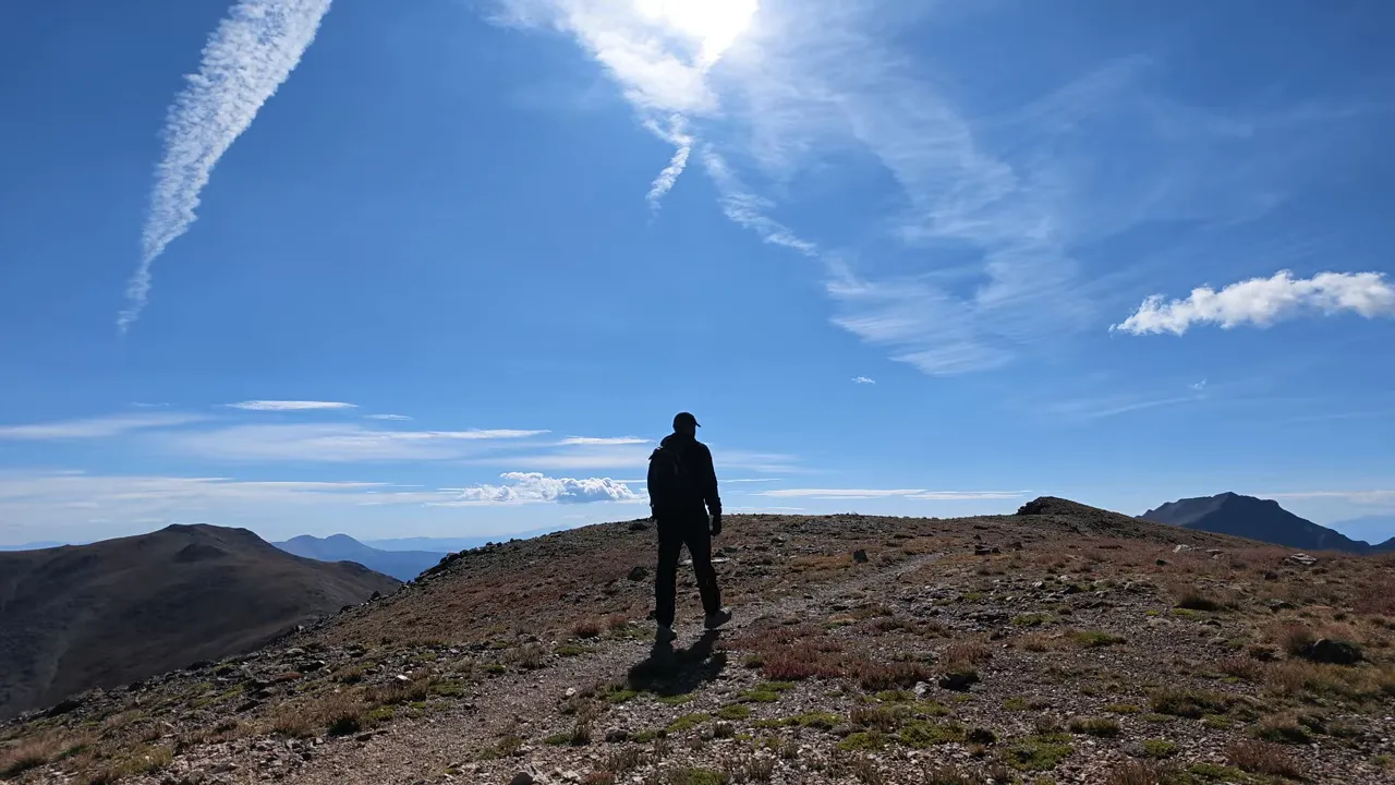 Rocky ridge descending toward a saddle and rising to a broad mountain summit