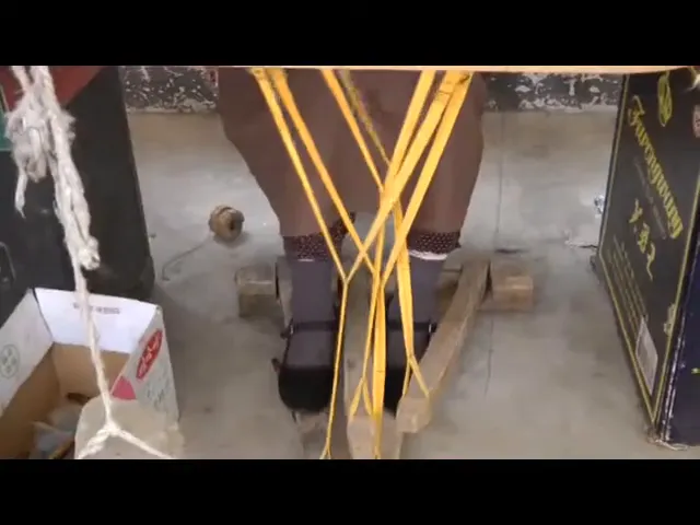 Piedi di un artigiano tibetano che controllano il telaio tramite pedali durante la realizzazione di un tappeto tibetano.
