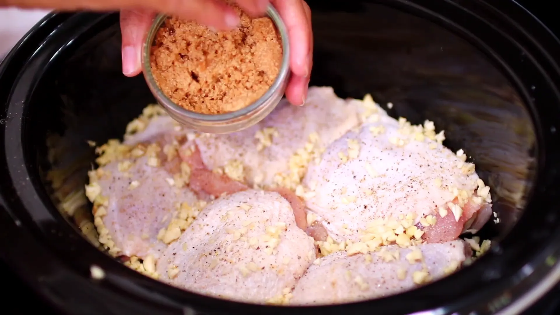 Adding minced garlic to chicken thighs