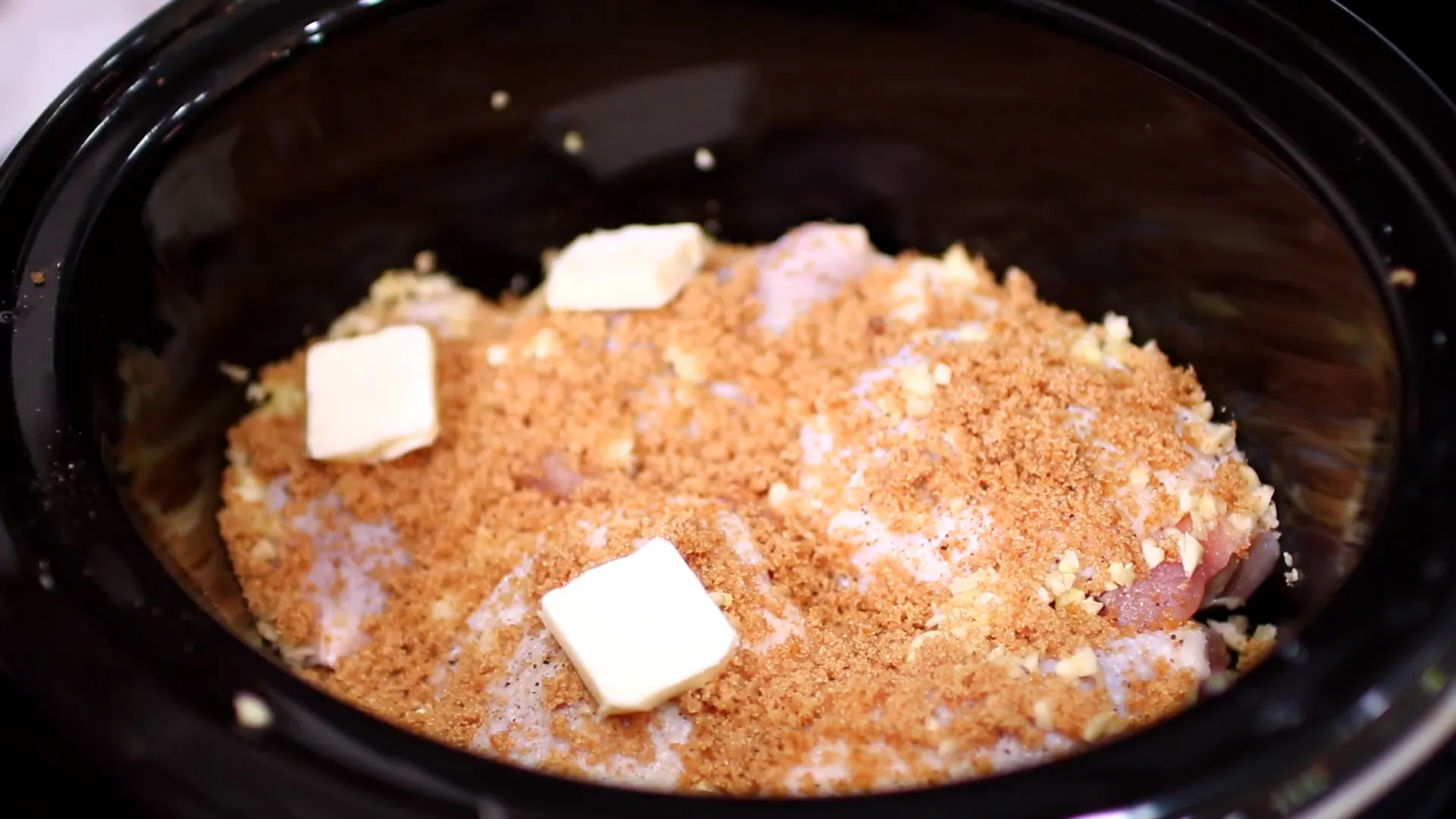 Placing butter slices on chicken thighs