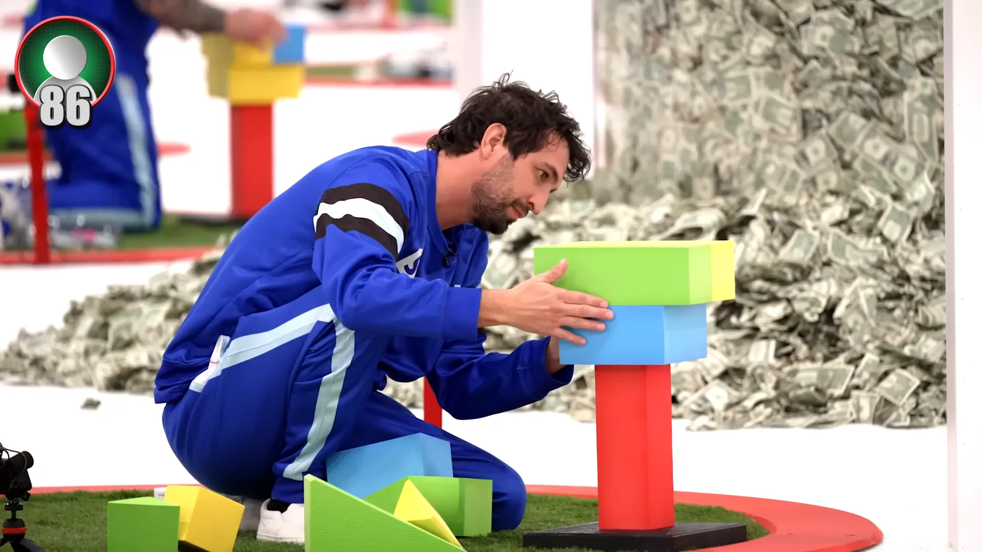 Contestants building towers on red cubes in their circles