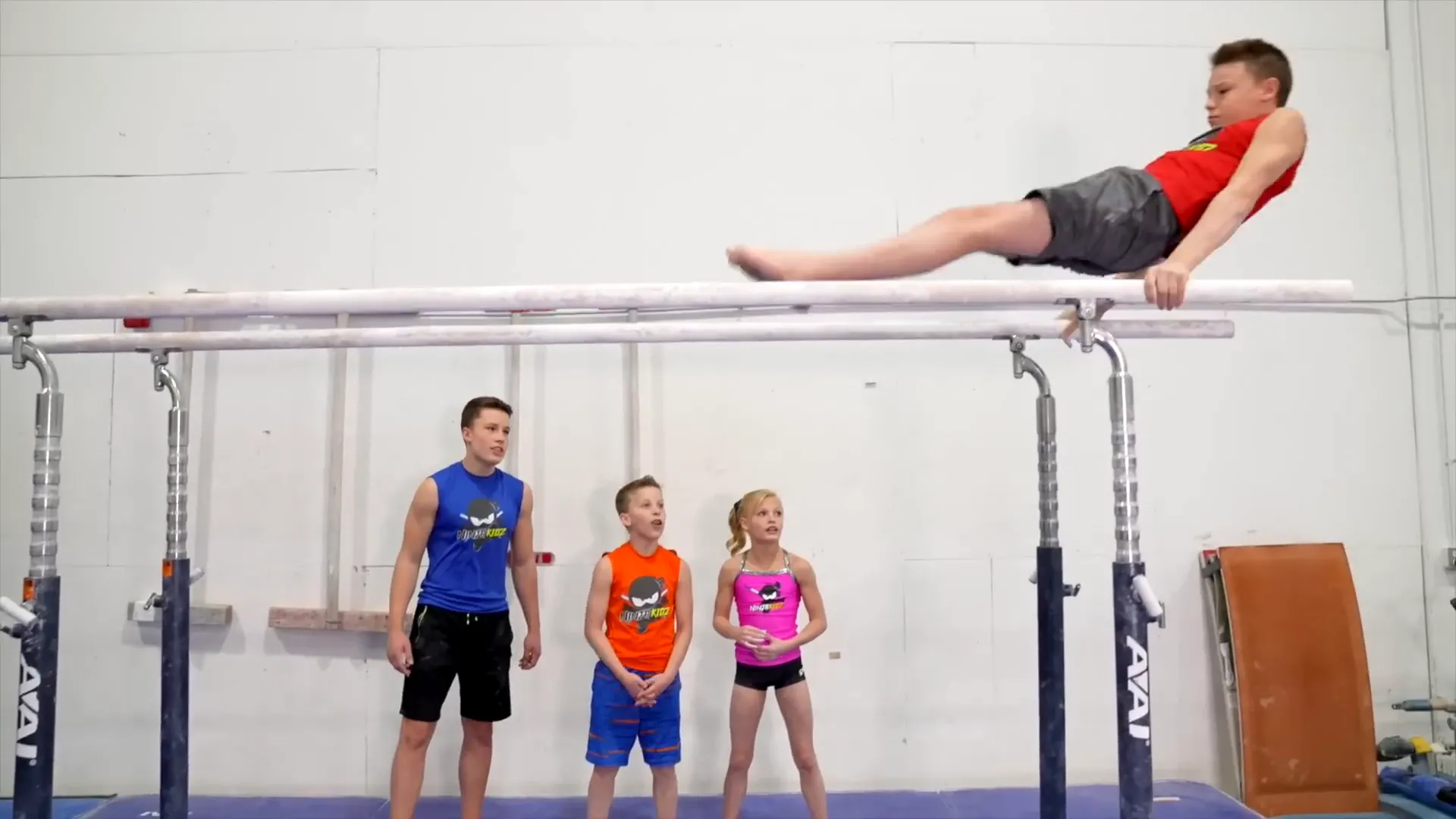 Ashton performing kip and peach on parallel bars