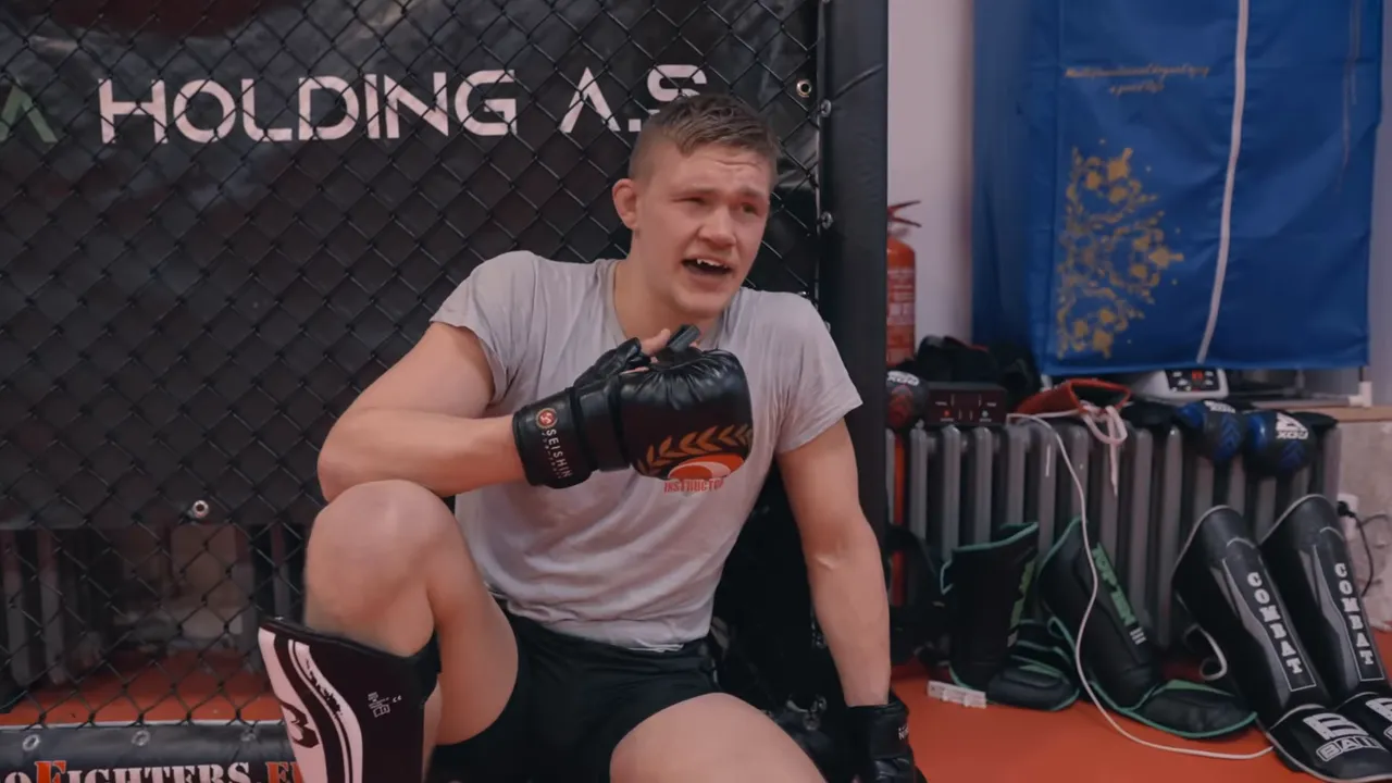 fighter sitting and catching breath against the cage after sparring
