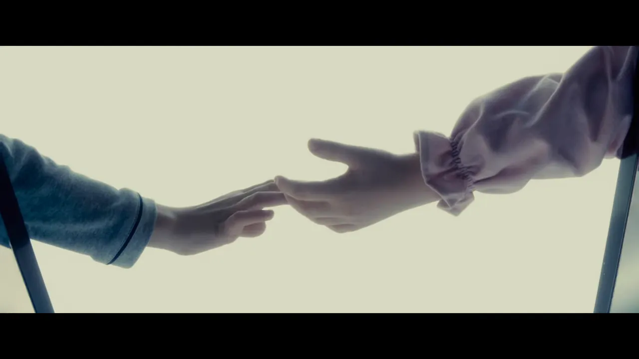 Two hands reaching toward each other against a bright background, symbolizing connection and revelation.