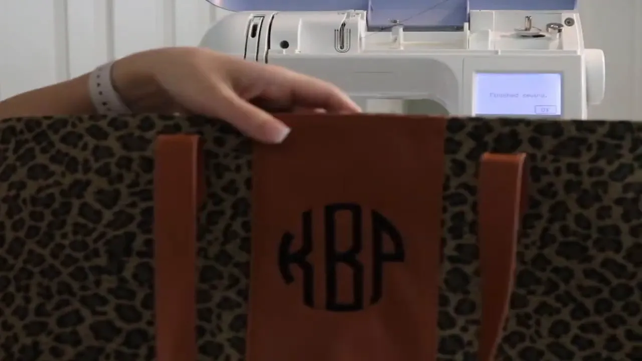 Leopard-print tote with a black circle monogram on its brown center strip