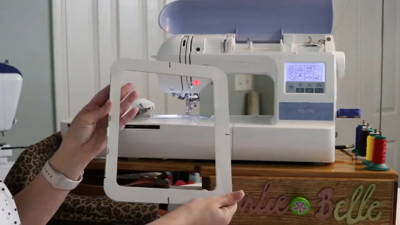 Flat rectangular magnetic embroidery hoop held in front of the machine