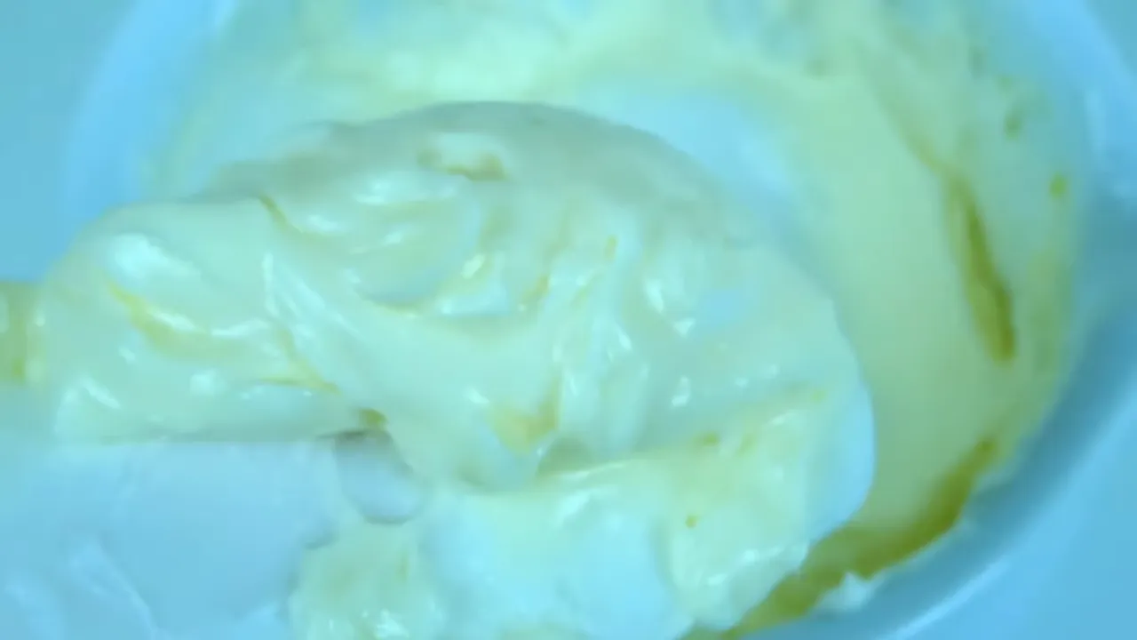 Detalle de la emulsión amarillenta con textura cremosa y uniforme en el mortero