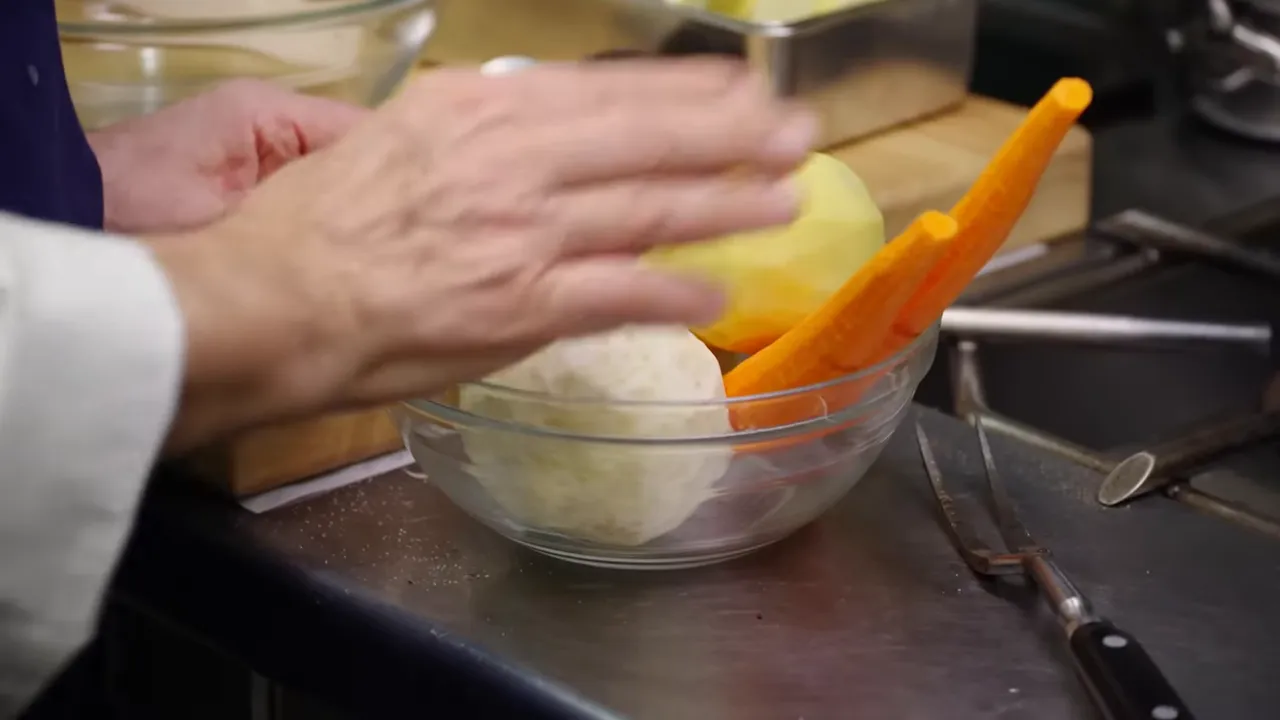 Vegetables being shredded in a bowl on a cutting board for pommes Darphin