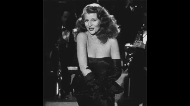 Black-and-white still of Rita Hayworth onstage in a strapless gown during a nightclub performance