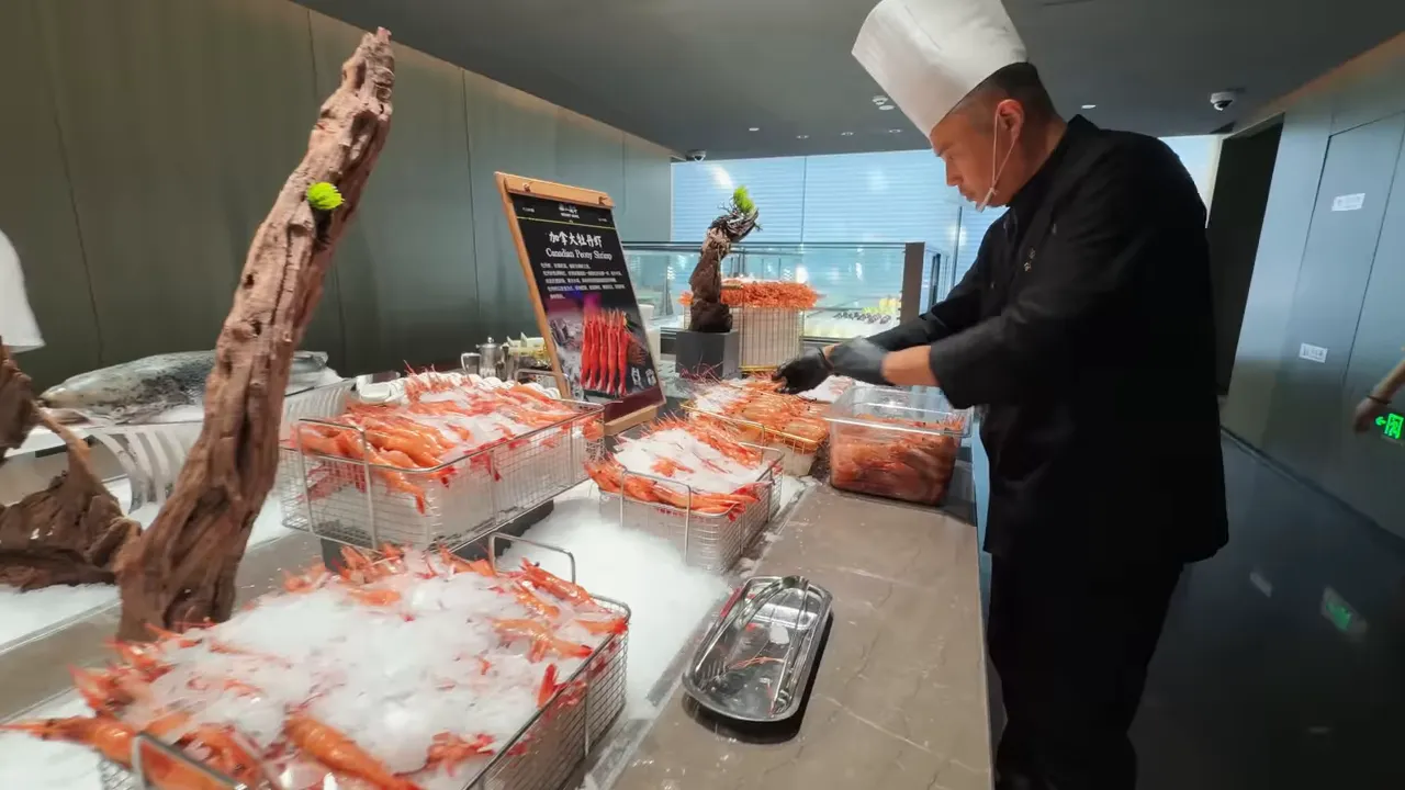 Buffet counter with trays of seafood and chilled dishes on ice