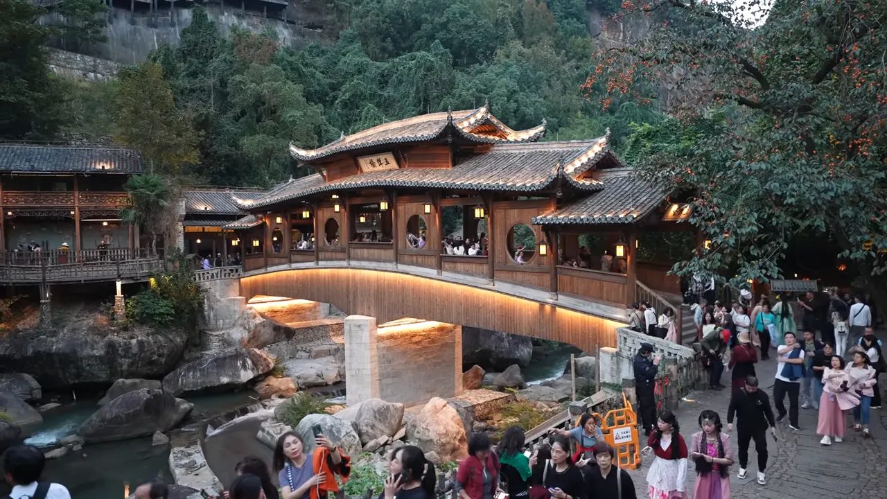 Hillside village with glowing buildings stacked along a cliff at dusk