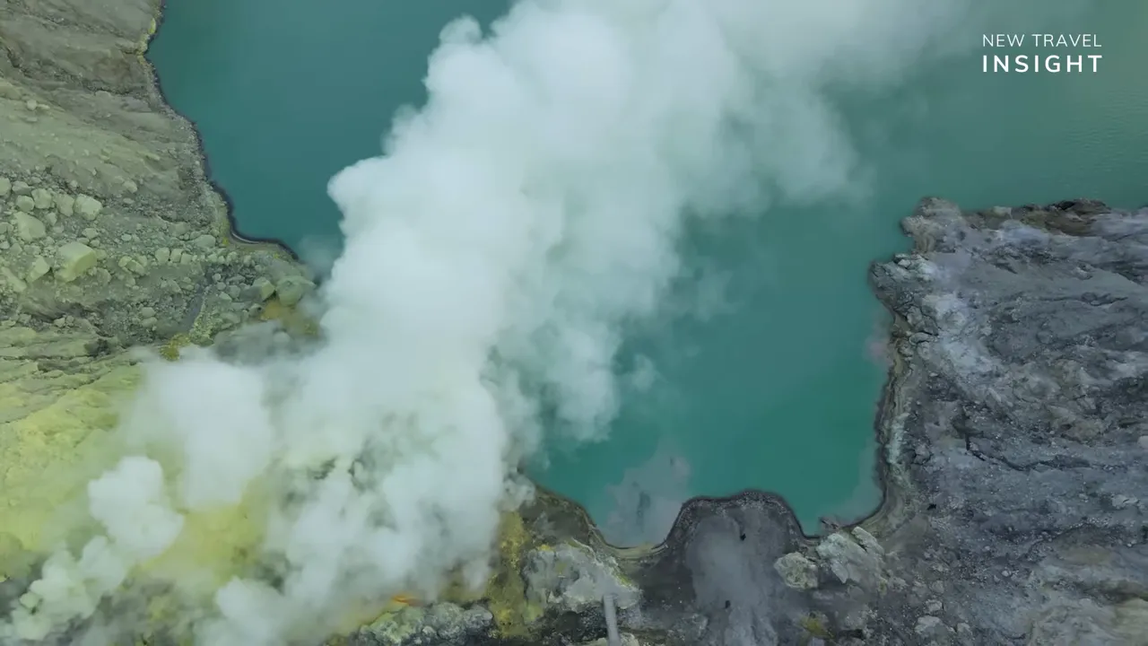 Steam rising across the basin of Kawah Ijen crater over turquoise volcanic water, Indonesia