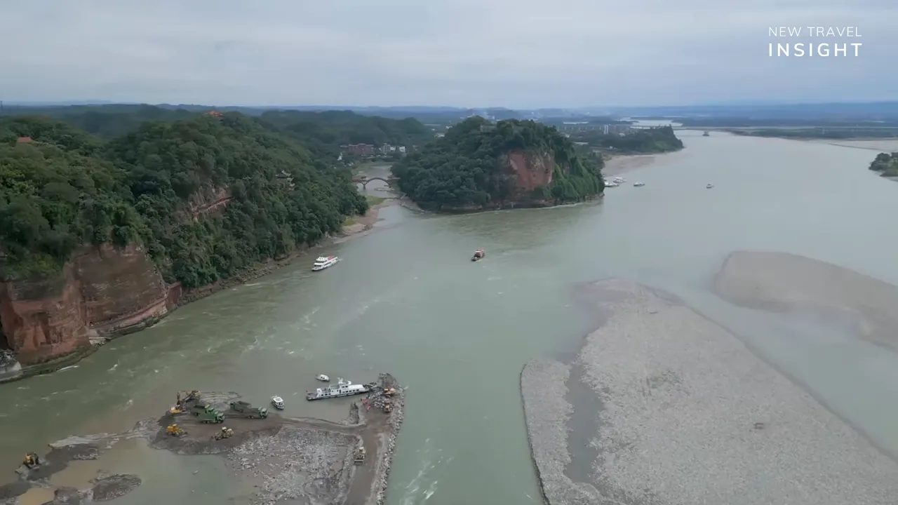 Aerial view of the Leshan Giant Buddha area showing the Min River bend, cliffs, and boats in China