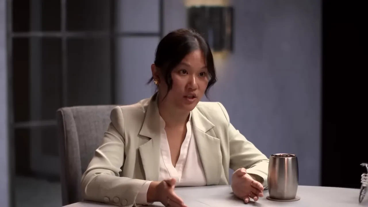 Karen Hao speaking during an interview with hands raised as she explains AI power and governance