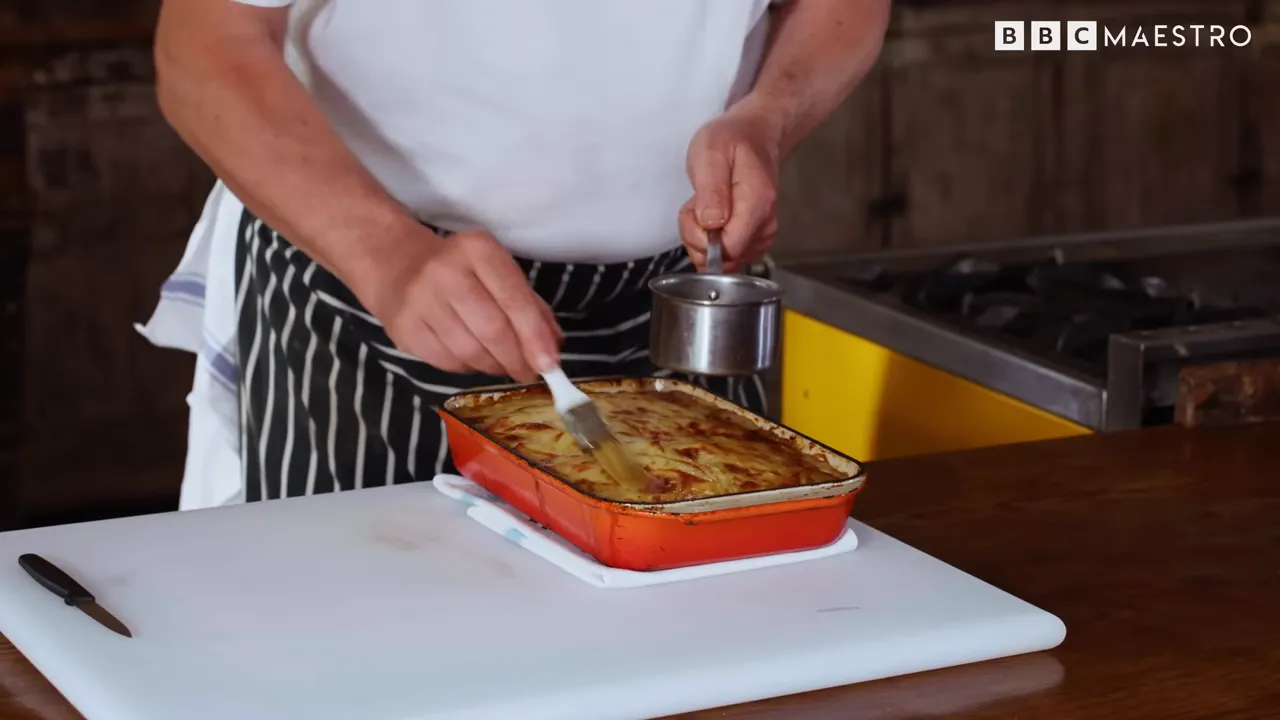 Chef loosening and releasing pommes boulangère from its dish