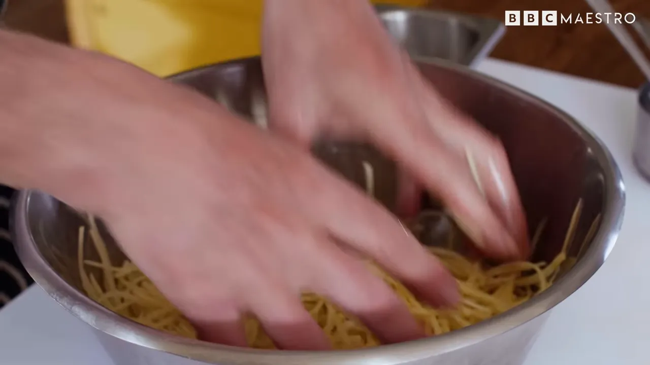 Hands pressing potato slices in a bowl to prep rösti