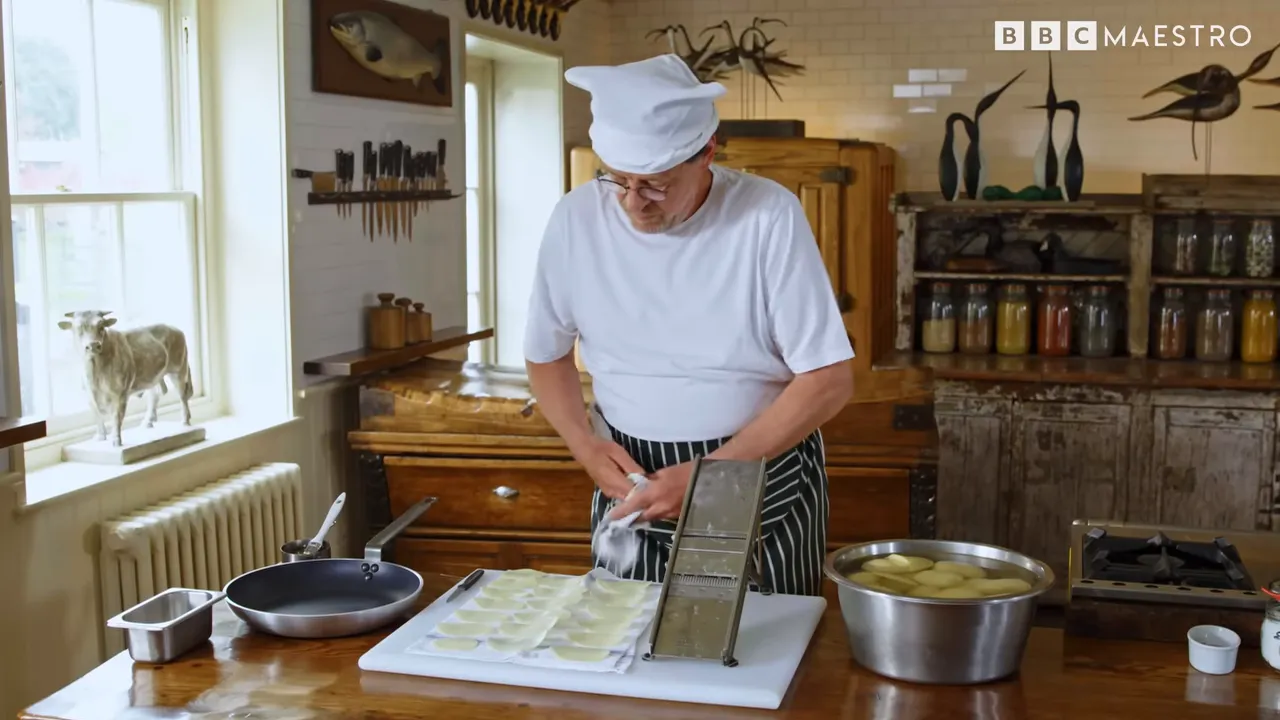 Chef slicing and drying potatoes on a cloth with a mandoline in a classic kitchen