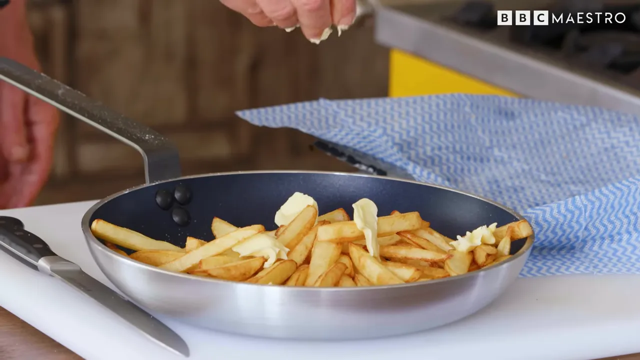 Butter poured over crisp potato chips on a serving pan