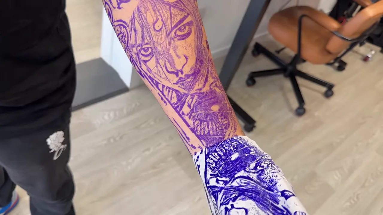 Purple stencil wrapped around a forearm with portrait, blossoms, and sword elements