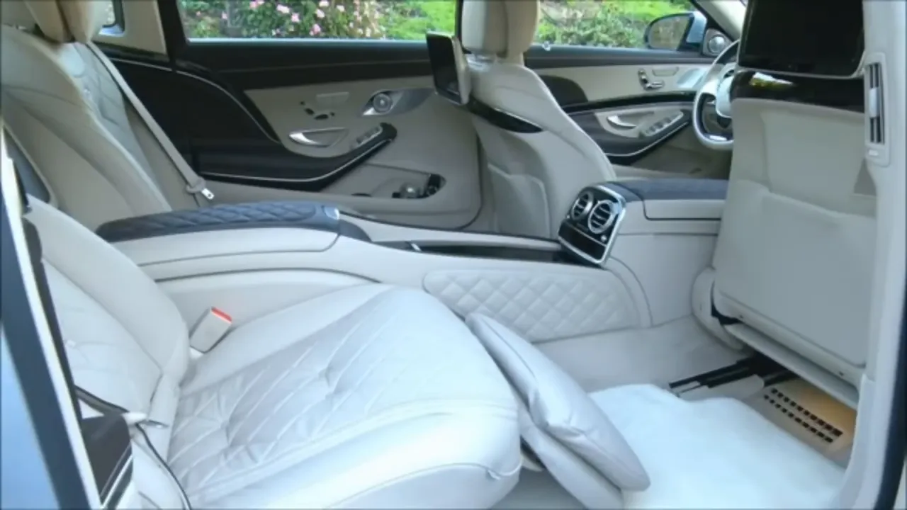 White Mercedes-Maybach rear cabin with reclining seats and pillows