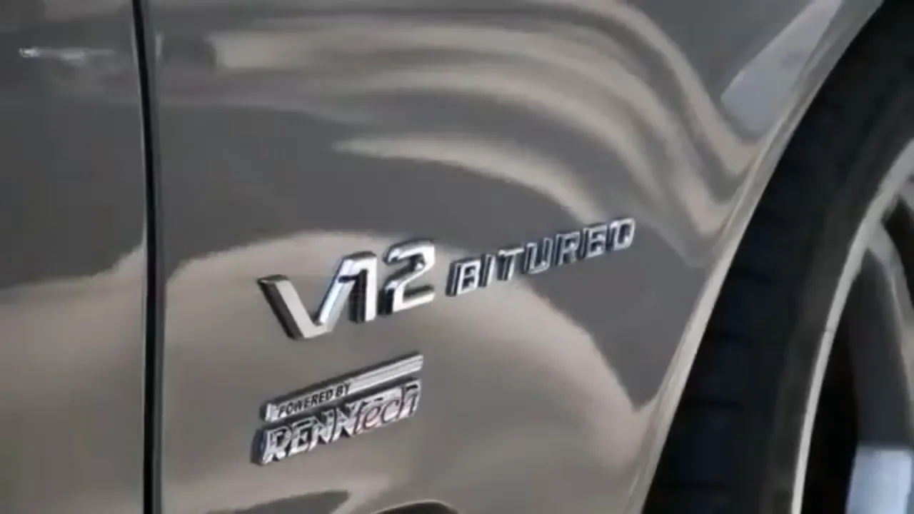 V12 Biturbo badge on the front fender of a silver Mercedes sedan