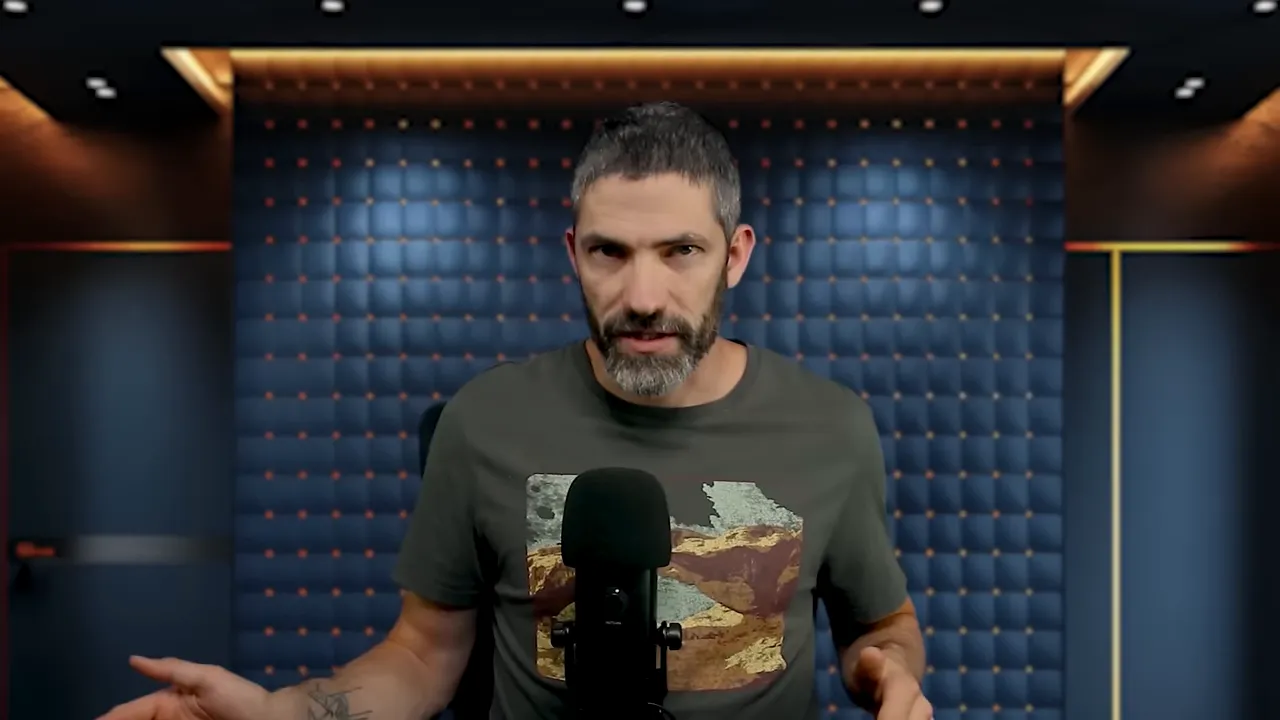 Presenter speaking into a microphone in a padded studio, hands visible and engaging with the camera.