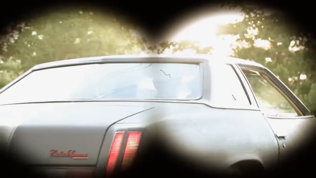 Aerial view of a busy 1970s expressway at night, car headlights streaming.