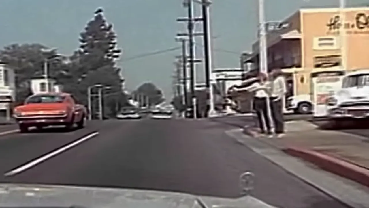 Faded 1970s street scene, silhouettes of young men walking along the road.