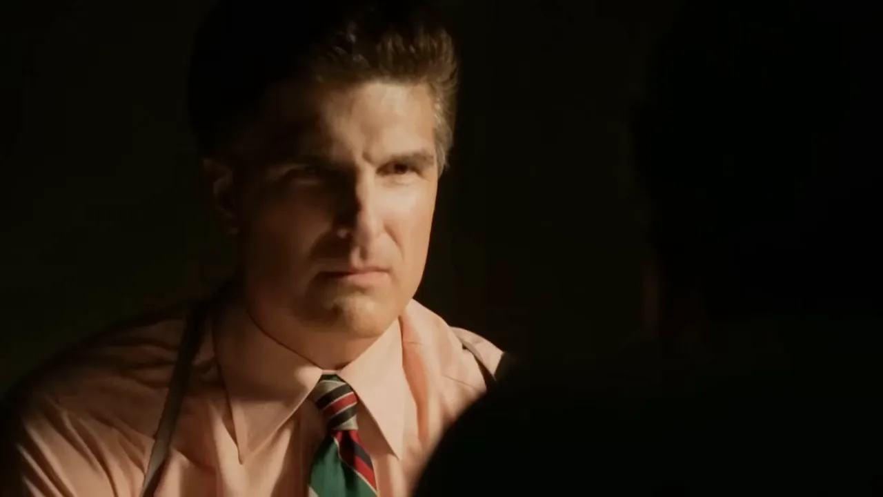 Detectives standing muted in a somber conference room after confronting a suspect.