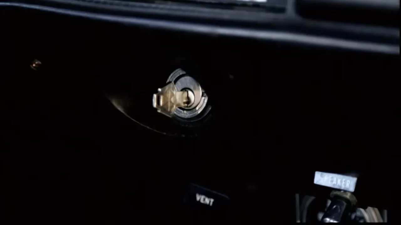 Close-up of a car parked near curb with keys visible in the ignition.