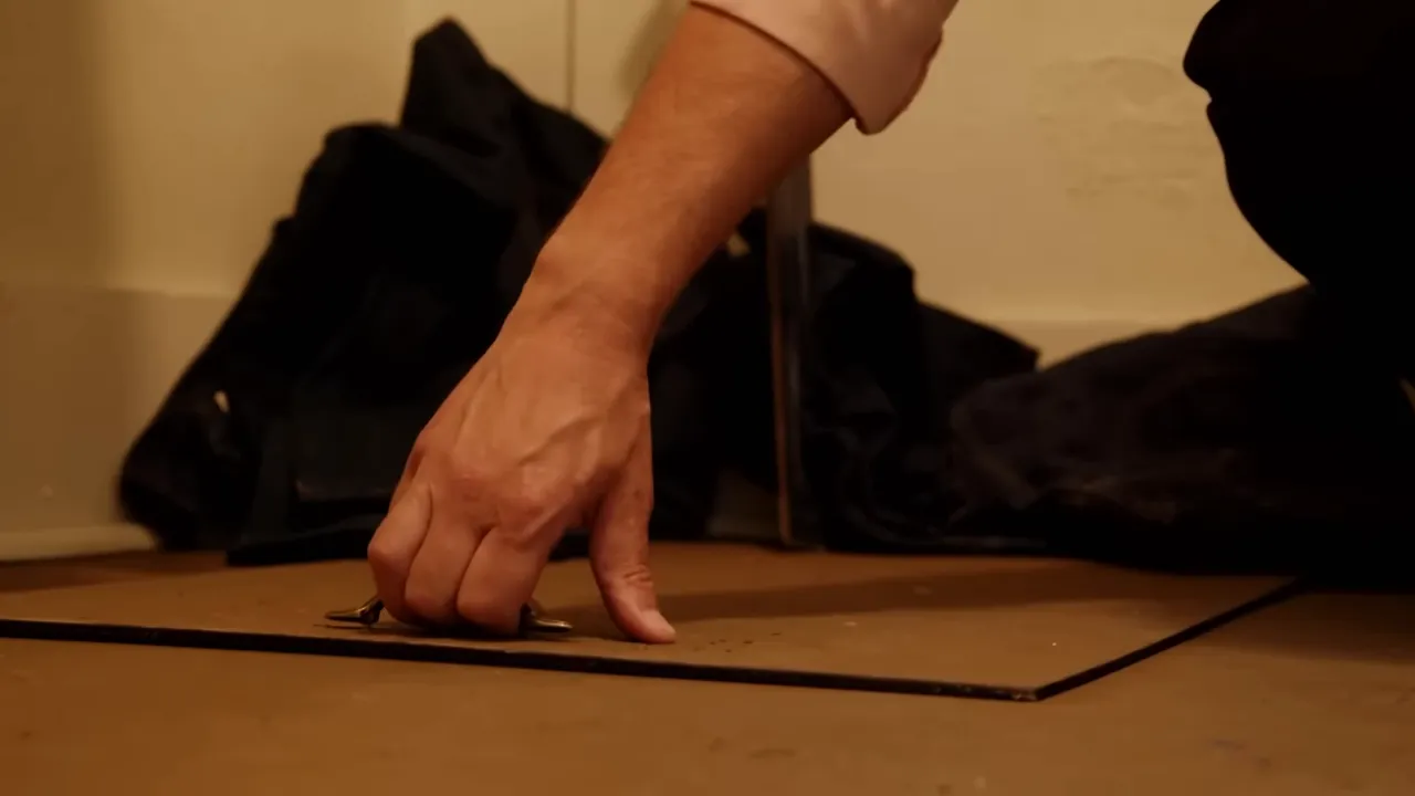 Dimly lit closet door being opened, revealing a narrow trap door.