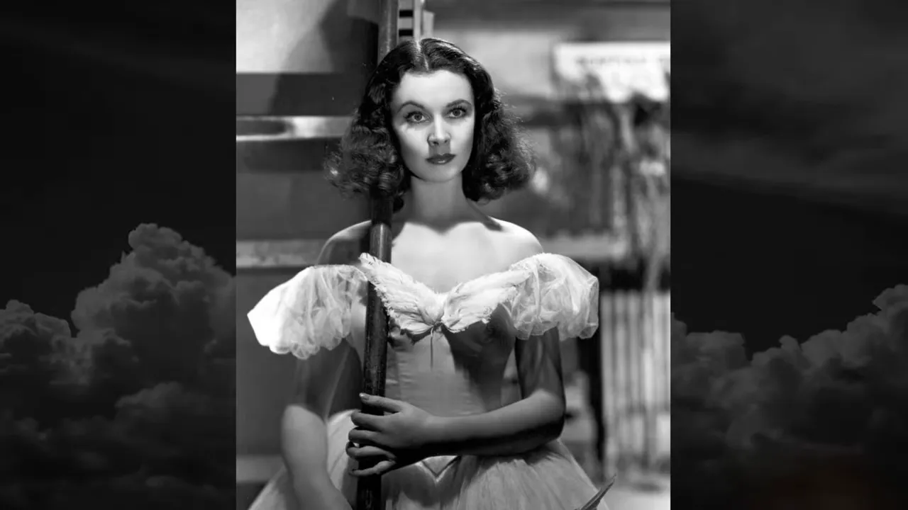 Black-and-white portrait of an actress in a stage costume holding a pole