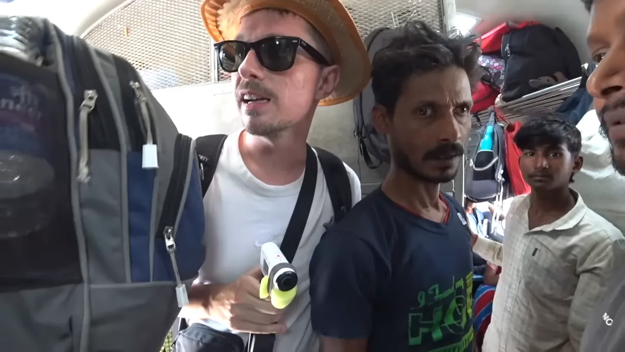 View of a toilet and sink area in an overcrowded Indian railway general compartment