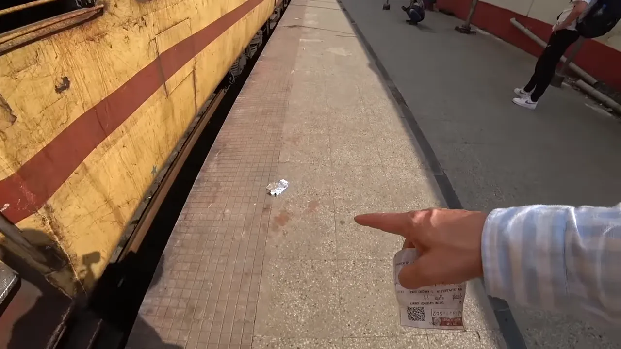 Trash and litter on a station platform beside railway carriage wall
