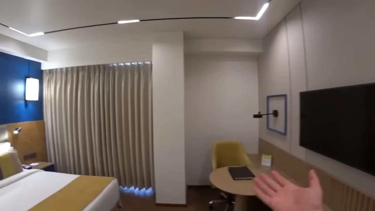 Clean hotel room interior with bed, desk, and curtains at Ramada Encore in Siliguri