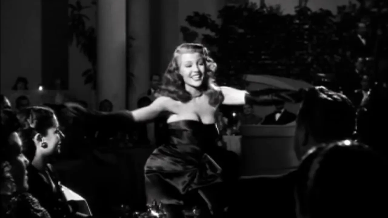 Black and white film still of Rita Hayworth performing on stage in Gilda