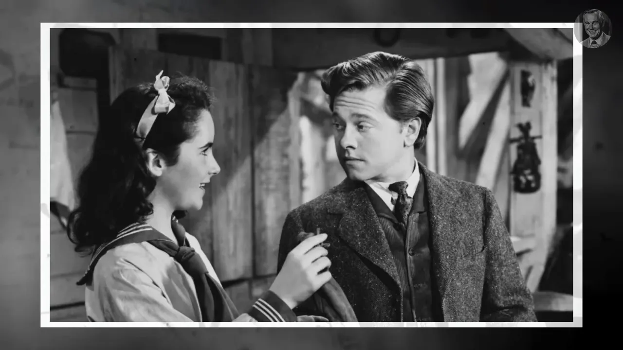 High-quality black-and-white film still showing a young female performer and an adult male co-star in conversation.