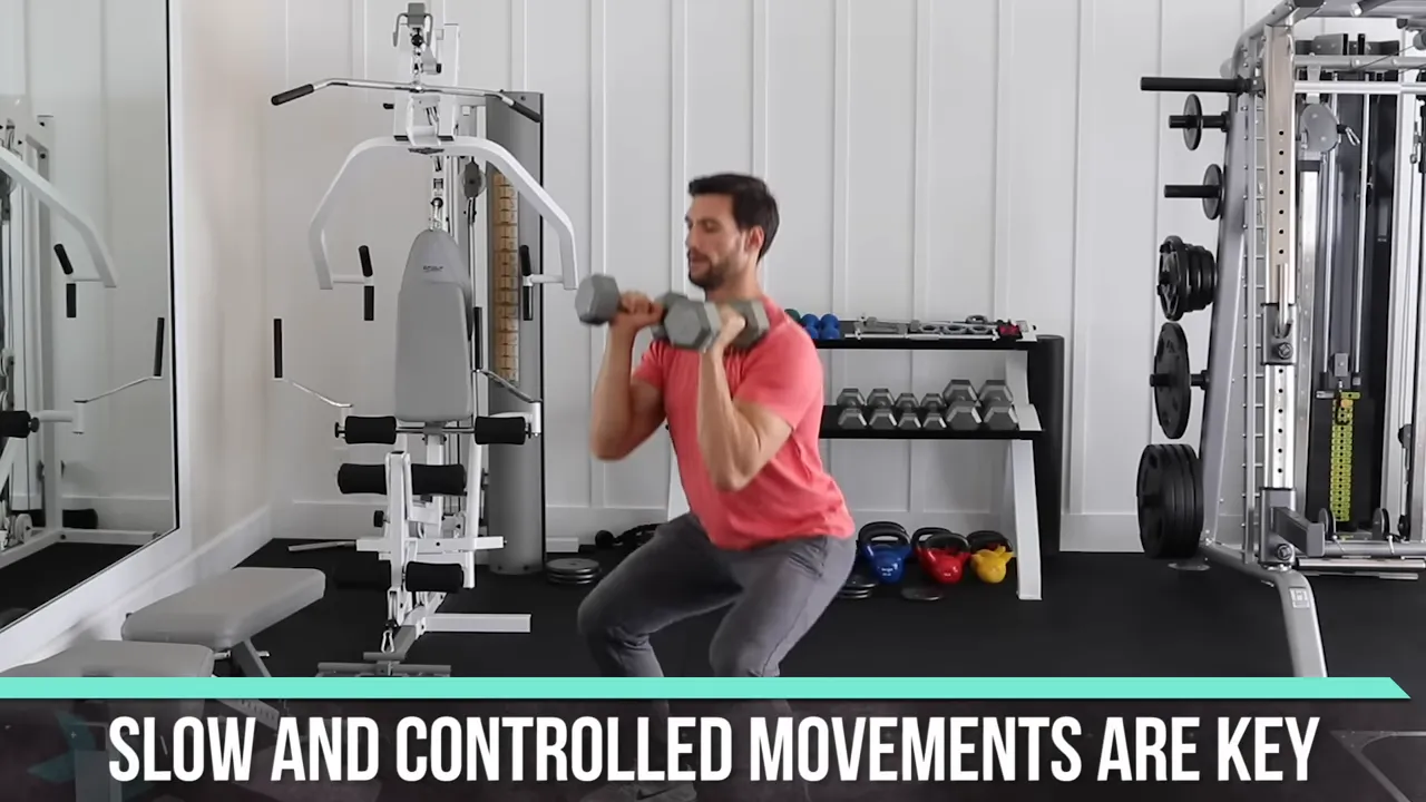Trainer holding dumbbells at shoulder height in the bottom position of a front squat