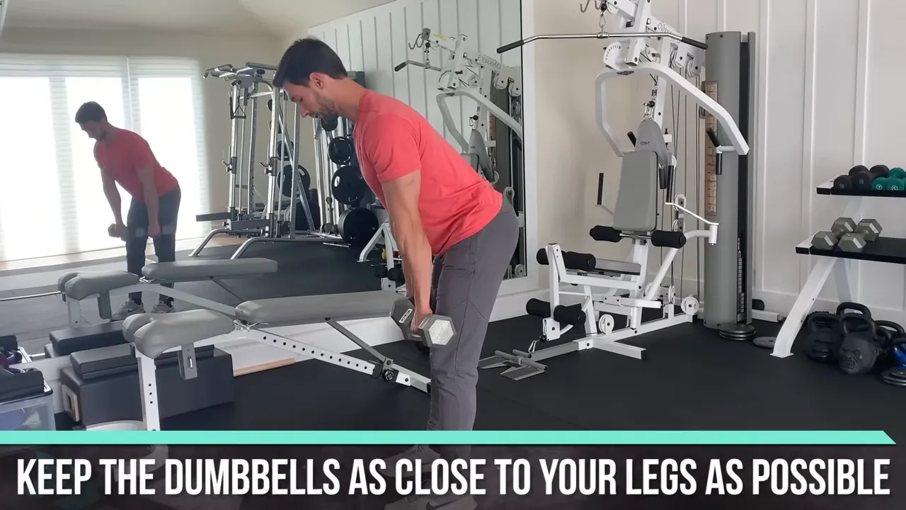 Trainer lowering dumbbells close to the legs during a stiff-leg deadlift